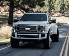White heavy duty pickup driving down the road. Click this image to Shop for Turbo-diesel Truck AMSOIL Lubrication